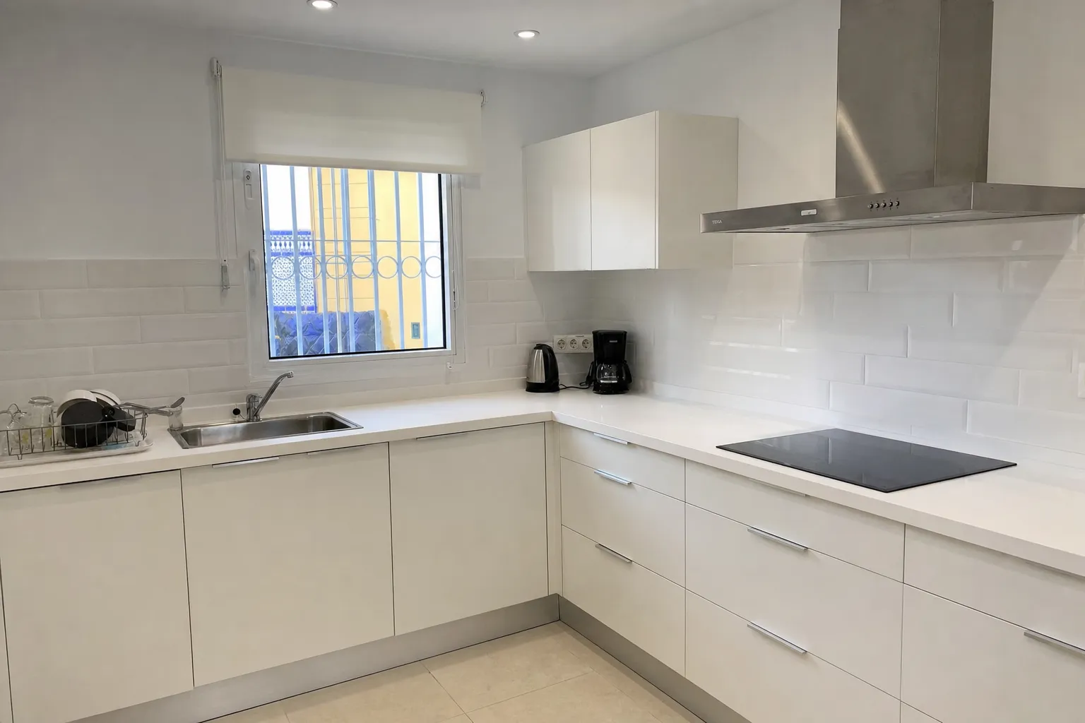 Renovated white kitchen with new cabinets and extractor